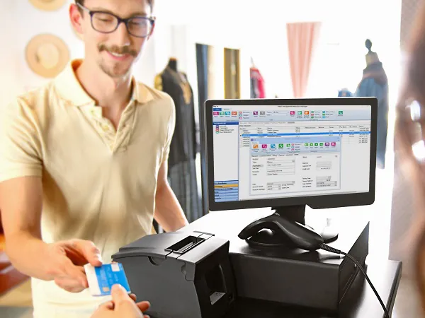 Cashier taking a card payment at a register running Retail Management Hero